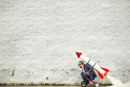 Man on a tricycle with a rocket on his back