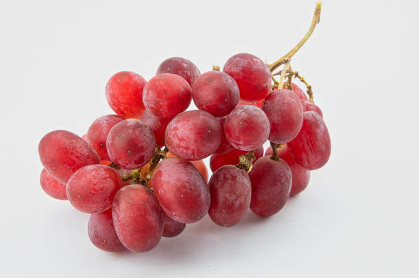 A bunch of red seedless grapes on a white background