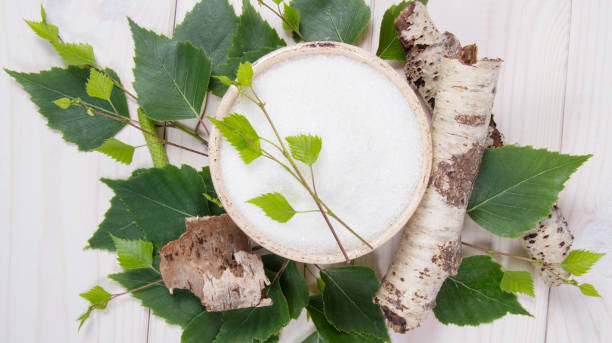 Xylitol - sugar substitute for diabetics. Birch sugar on white wooden background.
