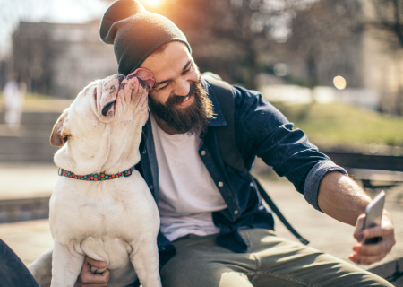 Man with dog on cellphone taking selfie